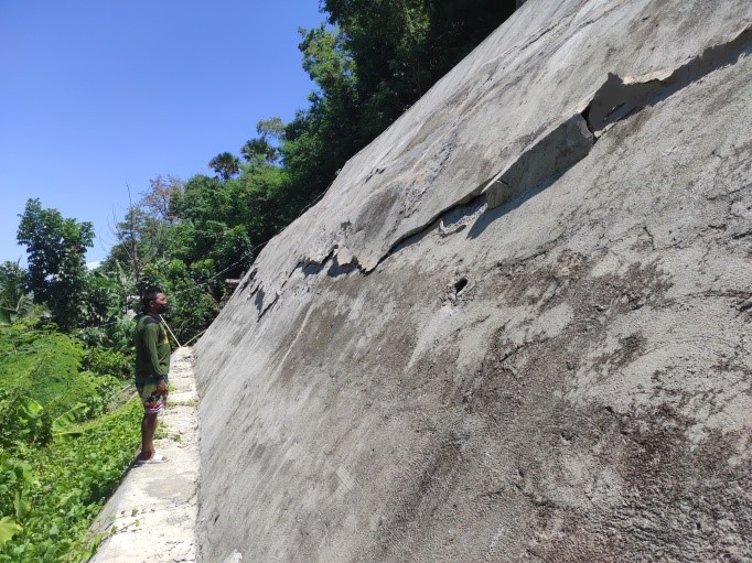 A damaged segment of a slope protection in Purok Marangkalan, Brgy. Basiao, Ivisan, Capiz with moderate to steep slopes. The slope protection was damaged due to the lack of drainage system and oversaturation of soil along the road. The area is classified as moderate to high on landslide susceptibility.
